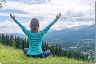 une femme fait de la méditation contemplative dans la nature