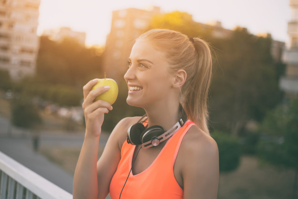 Une femme mange une pomme